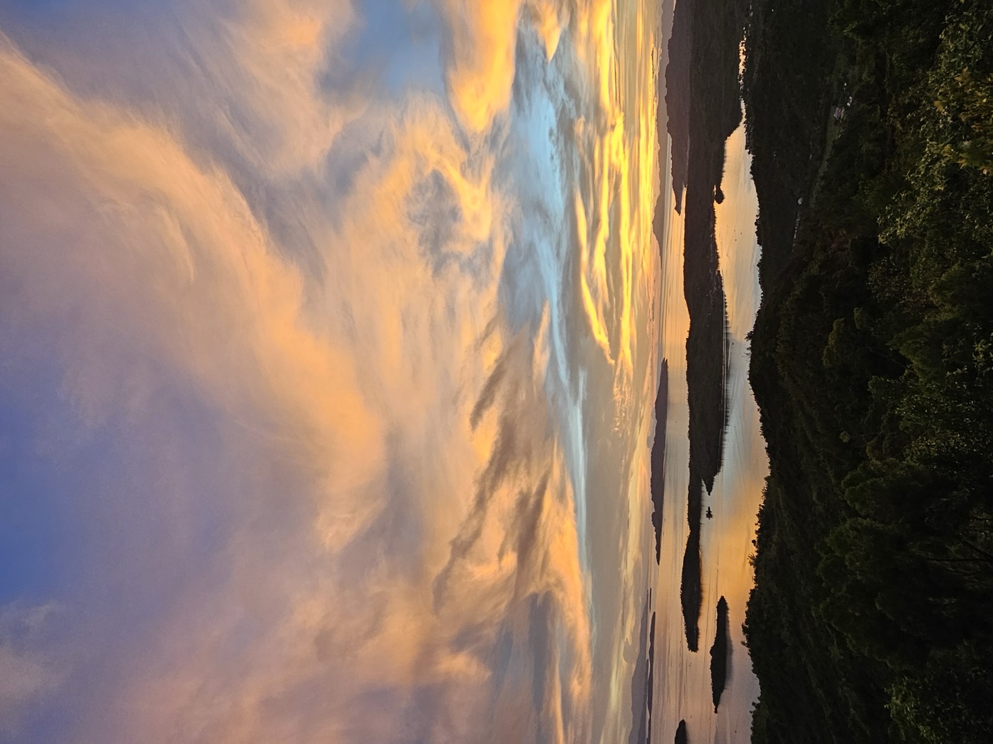 Golden sunset clouds over the sea and islands, seen from Laaganan